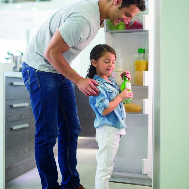 dad helps daughter at refrigerator